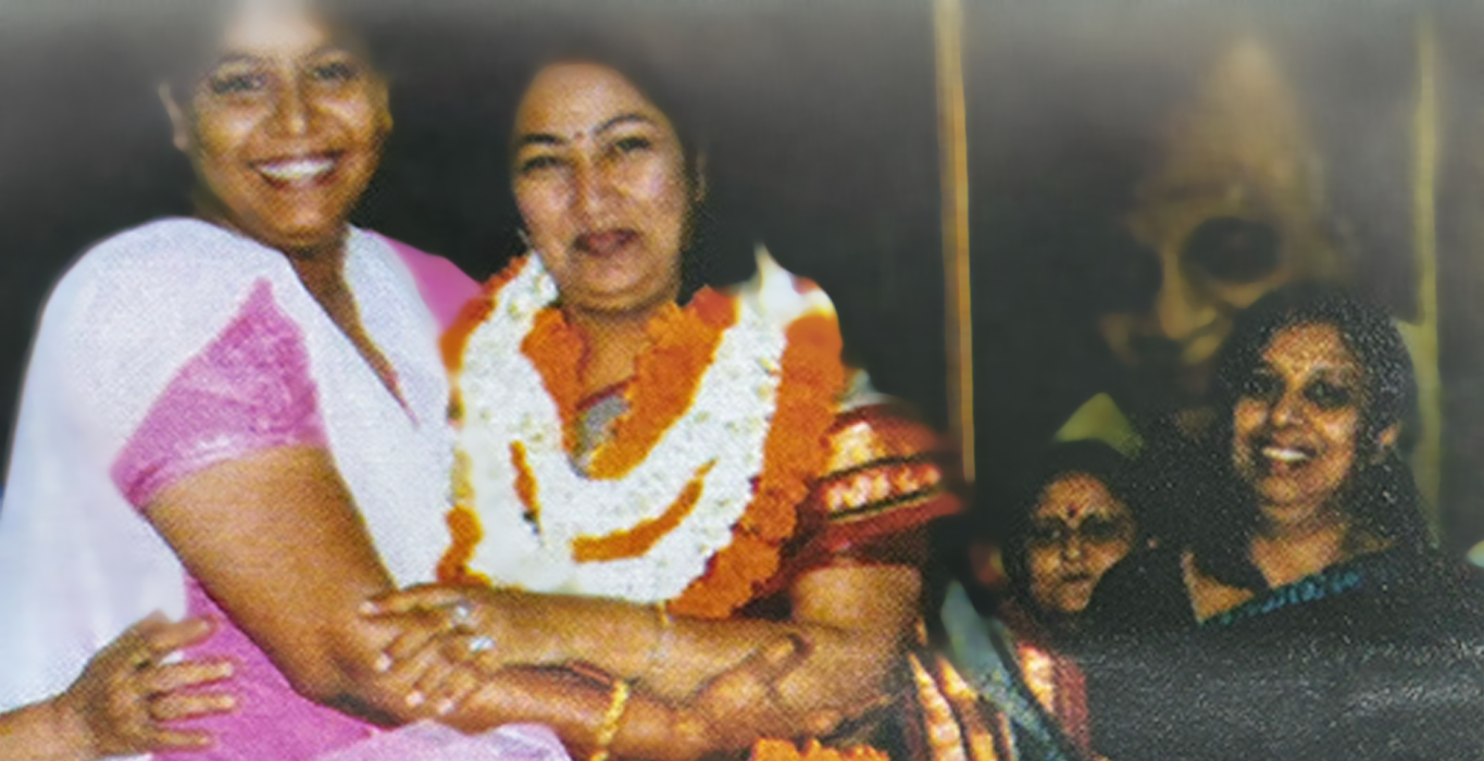 Rekha Gupta wearing flower garlands and being congratulated by women at a gathering
