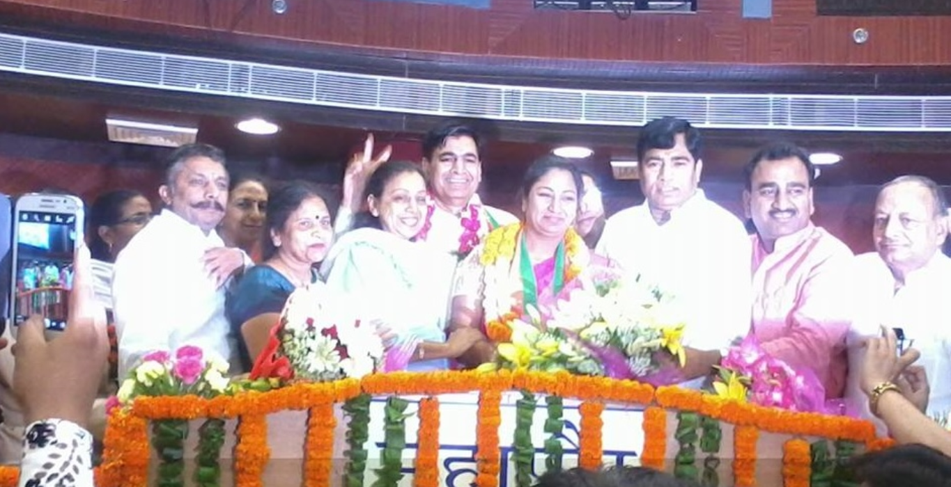 Rekha Gupta receiving floral tributes alongside fellow leaders at a felicitation ceremony