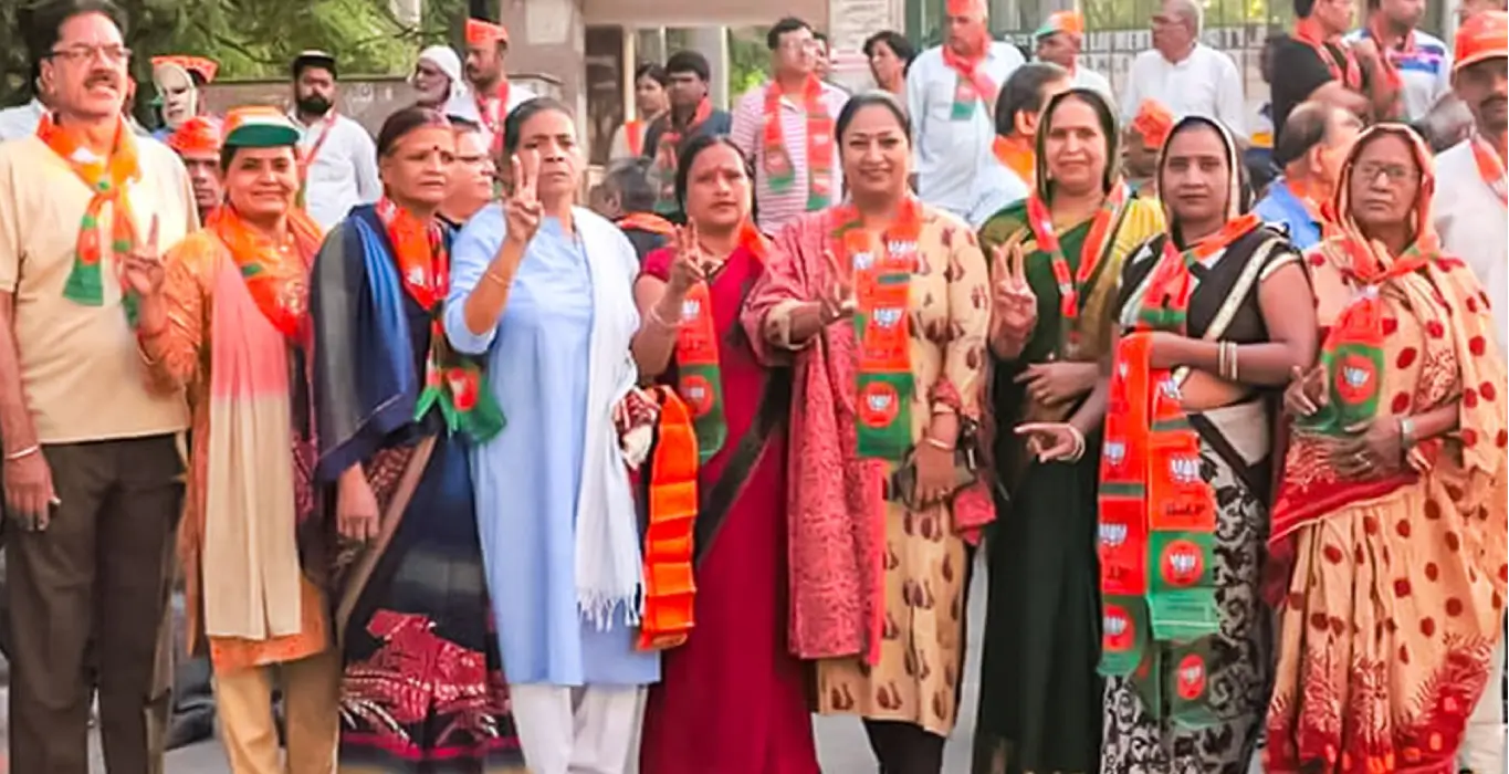 Rekha Gupta with Mahila Morcha members wearing party scarves and displaying victory signs